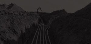 An excavator digging a complex series of trenches to lay conduit.