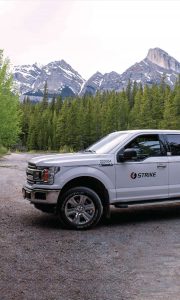 A Strike company truck in front of the mountains.