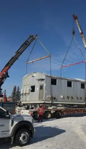 Construction trailer being loaded on a truck