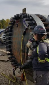 A female worker resting her arm on a large petrochemical pipe