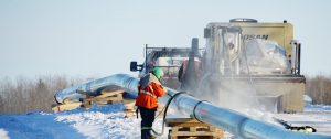 Workers working on a pipe in the snow on a cold winter day